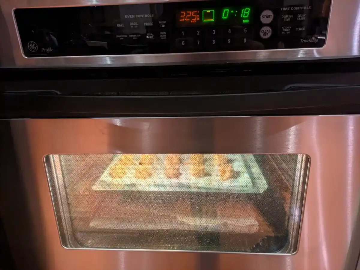 A close-up photo of a stainless steel GE Profile oven with its digital display showing 325°F and a timer at 18 seconds…