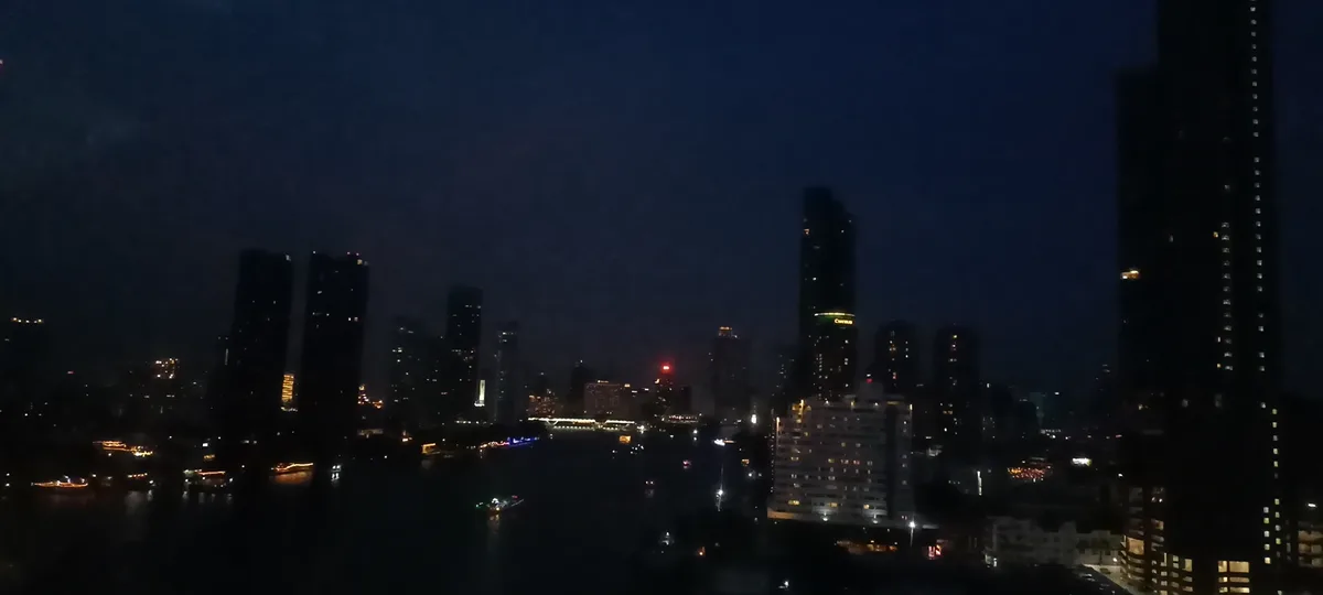 A nighttime cityscape with tall buildings, a river with boats, and dim lights under a dark sky. Overlaid text reads 'i'm not…