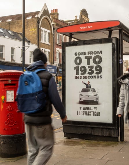 A person walks past a bus stop advertisement for Tesla that humorously claims the car goes from 0 to 1939 in 3 seconds, with…