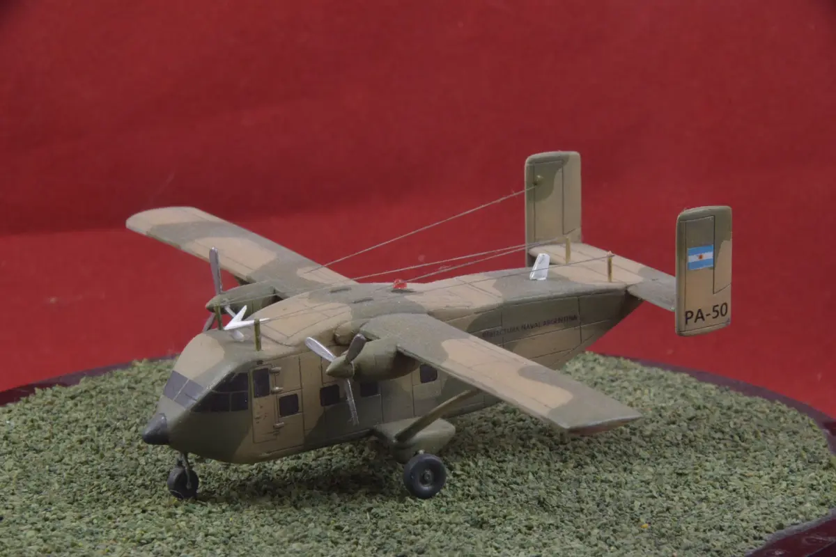 A detailed scale model of a military transport aircraft, painted in camouflage with 'PREFECTURA NAVAL ARGENTINA' and 'PA-50'…