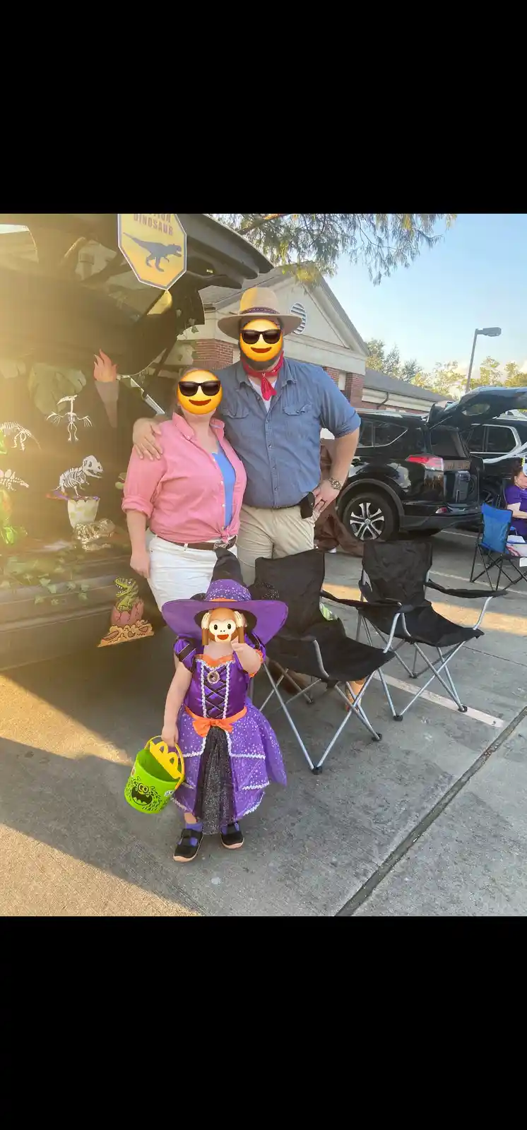 A family poses in front of a car decorated with dinosaur skeletons and a 'Dinosaur' sign. The adults have emoji faces, and a…