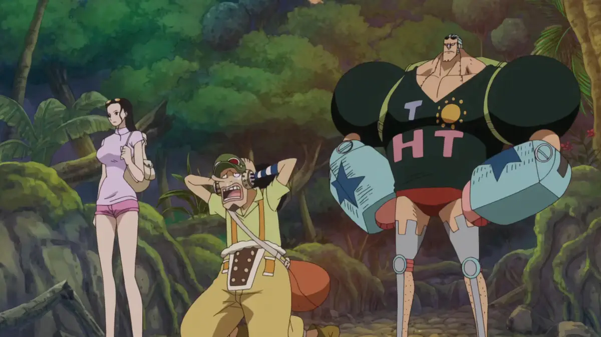 In a jungle setting, a large, muscular man with a black tank top featuring the letters 'T H T' and mechanical arms stands…