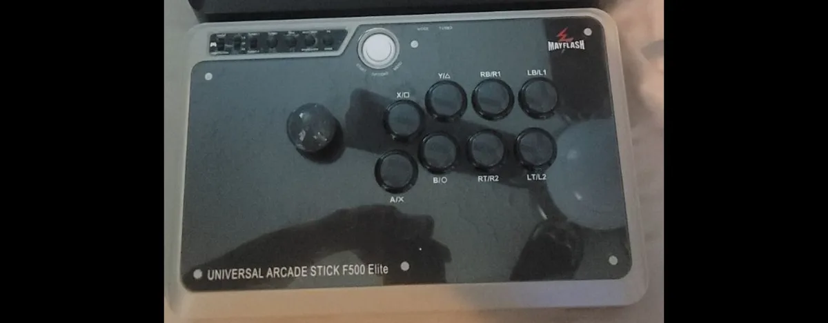 A Mayflash Universal Arcade Stick F500 Elite controller is shown, featuring a joystick, eight buttons labeled with gamepad…
