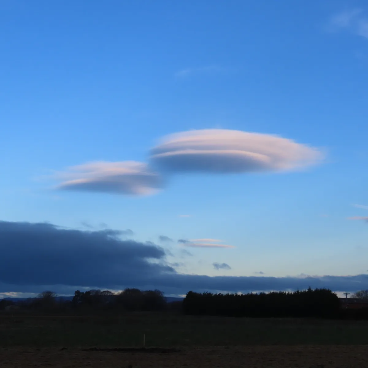 Mysterious UFO-shaped clouds hover over Winter Hill, UK