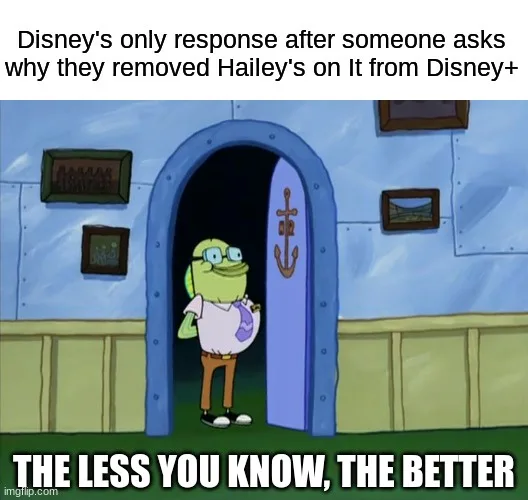 A cartoon image of a green-skinned character with glasses, wearing a white shirt and brown pants, standing in a doorway with…