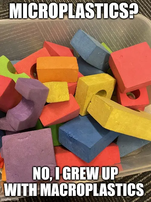 A clear plastic bin filled with colorful, large, interlocking foam blocks resembling oversized LEGO bricks. The blocks are…