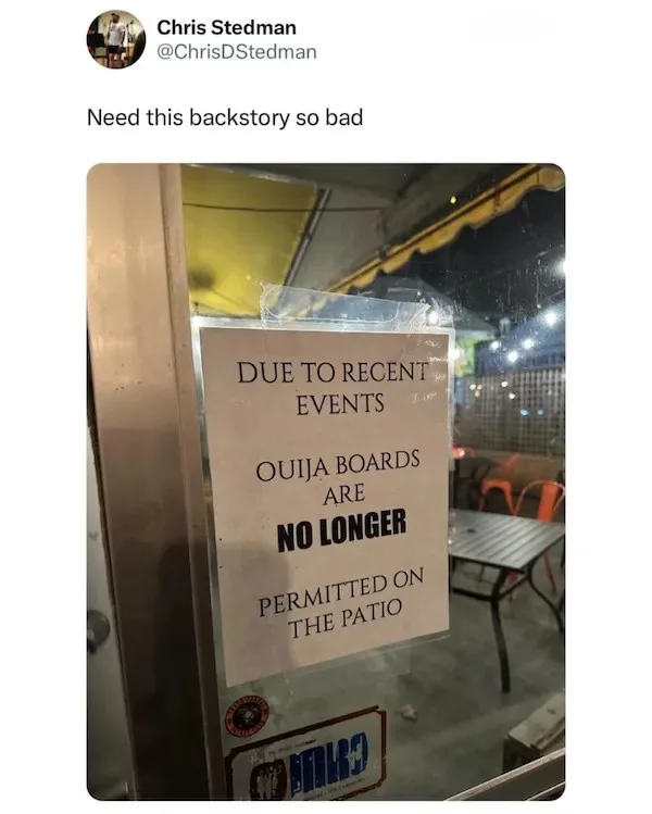 A sign taped to a glass door or window of an establishment states that due to recent events, ouija boards are no longer…