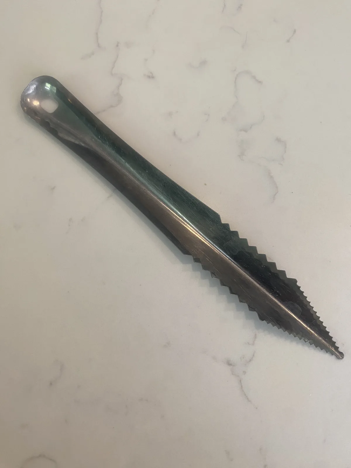 A metal butter knife with a serrated edge lies diagonally on a white marble countertop. The overlaid text reads 'i'm not a…