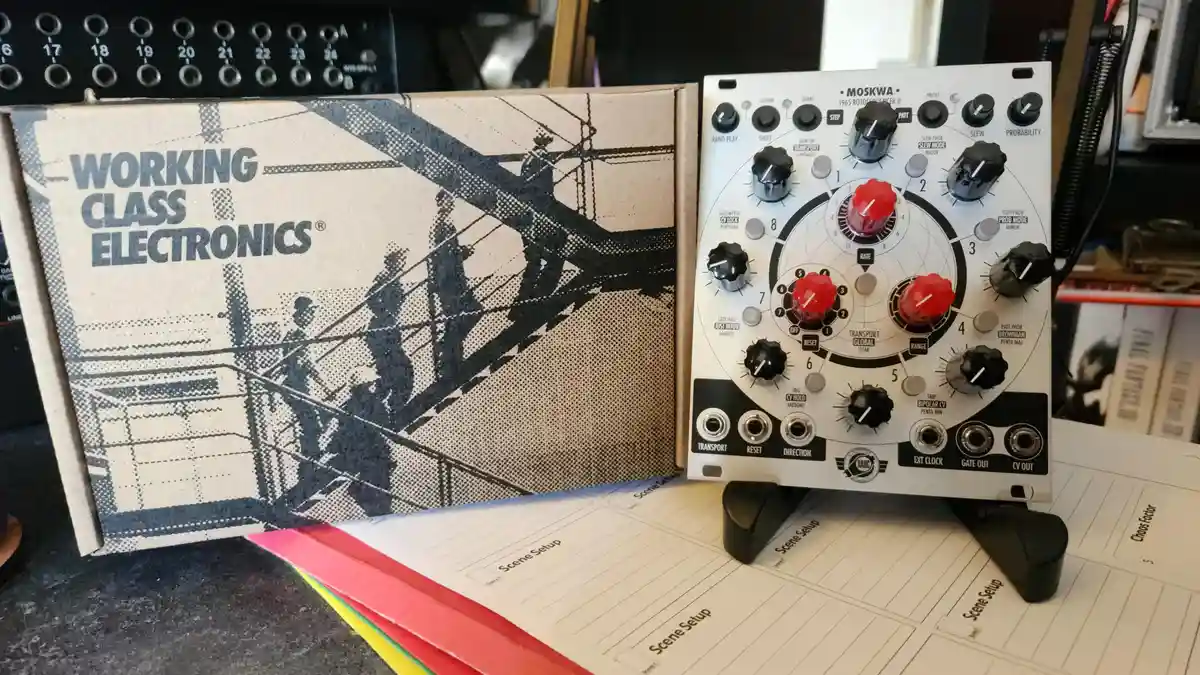 A white MOSKWA 1965 Rotosequencer II analog synthesizer module sits next to its 'Working Class Electronics' branded box…