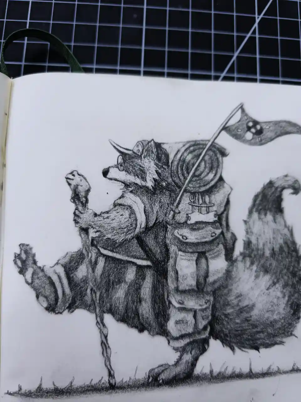 A pencil sketch in a notebook shows a raccoon wearing armor, holding a bone, and carrying a flag with a raccoon face on it…