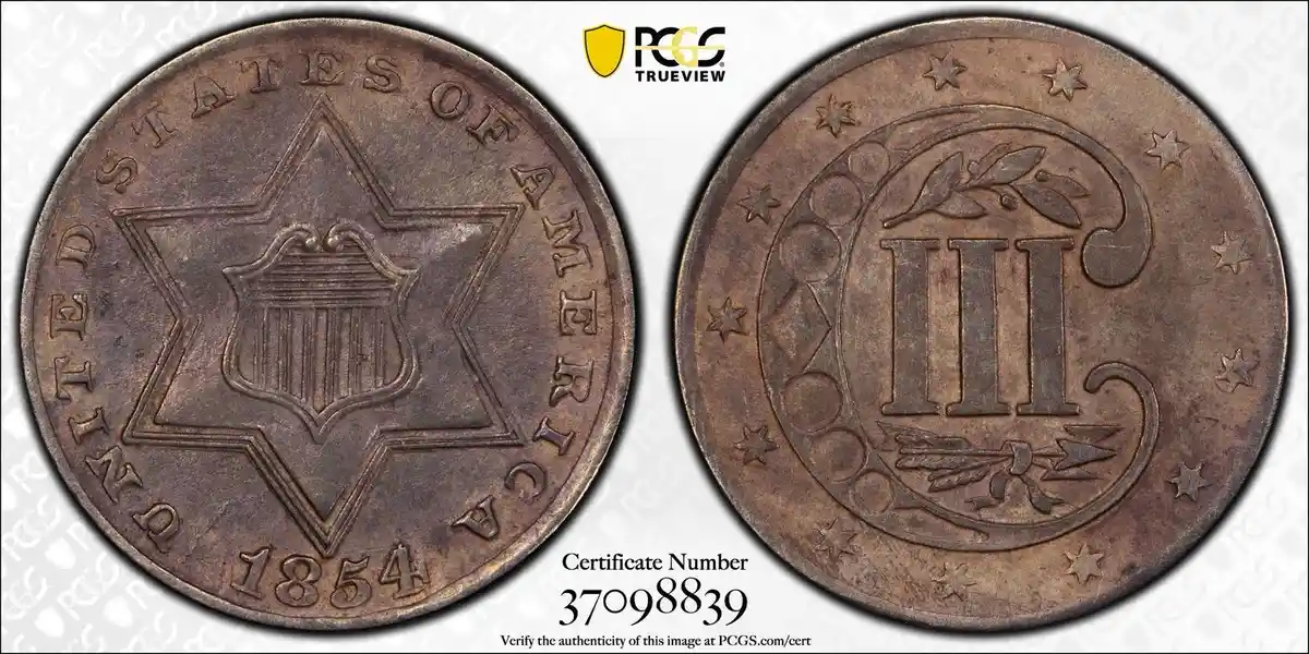 The image displays two sides of a copper-colored 1854 United States three-cent coin, with the obverse showing a shield…