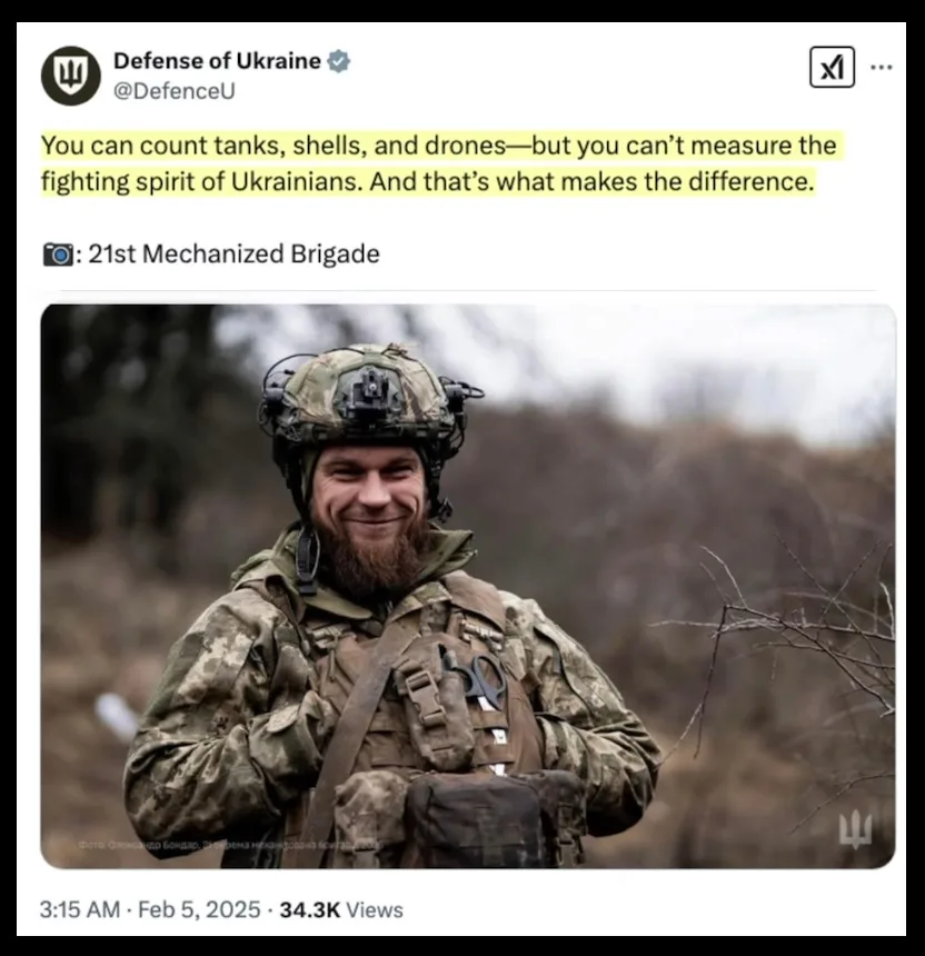 A Ukrainian soldier in full combat gear, including a helmet and tactical vest, smiles confidently at the camera outdoors…