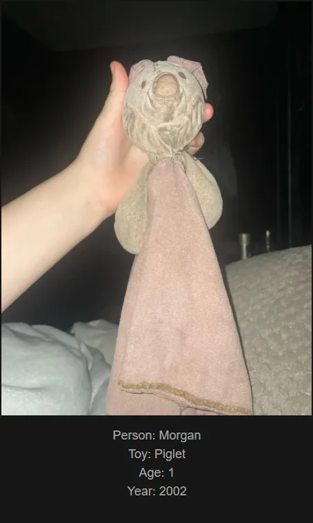 A hand holds a worn, beige fabric toy shaped like a piglet with a simple stitched face and a long, soft cloth tail. The toy…