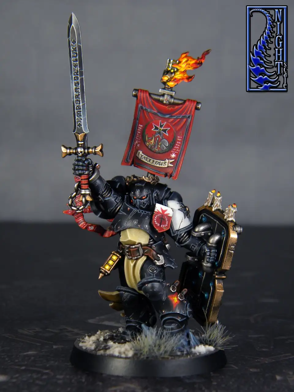 A painted miniature of a heavily armored warrior, likely from Warhammer 40,000, holding a sword inscribed with 'IMPERATOR'…
