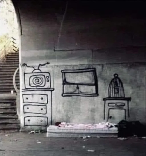 A black-and-white photo shows a gritty urban underpass with a concrete wall. On the wall, simple black chalk drawings depict…