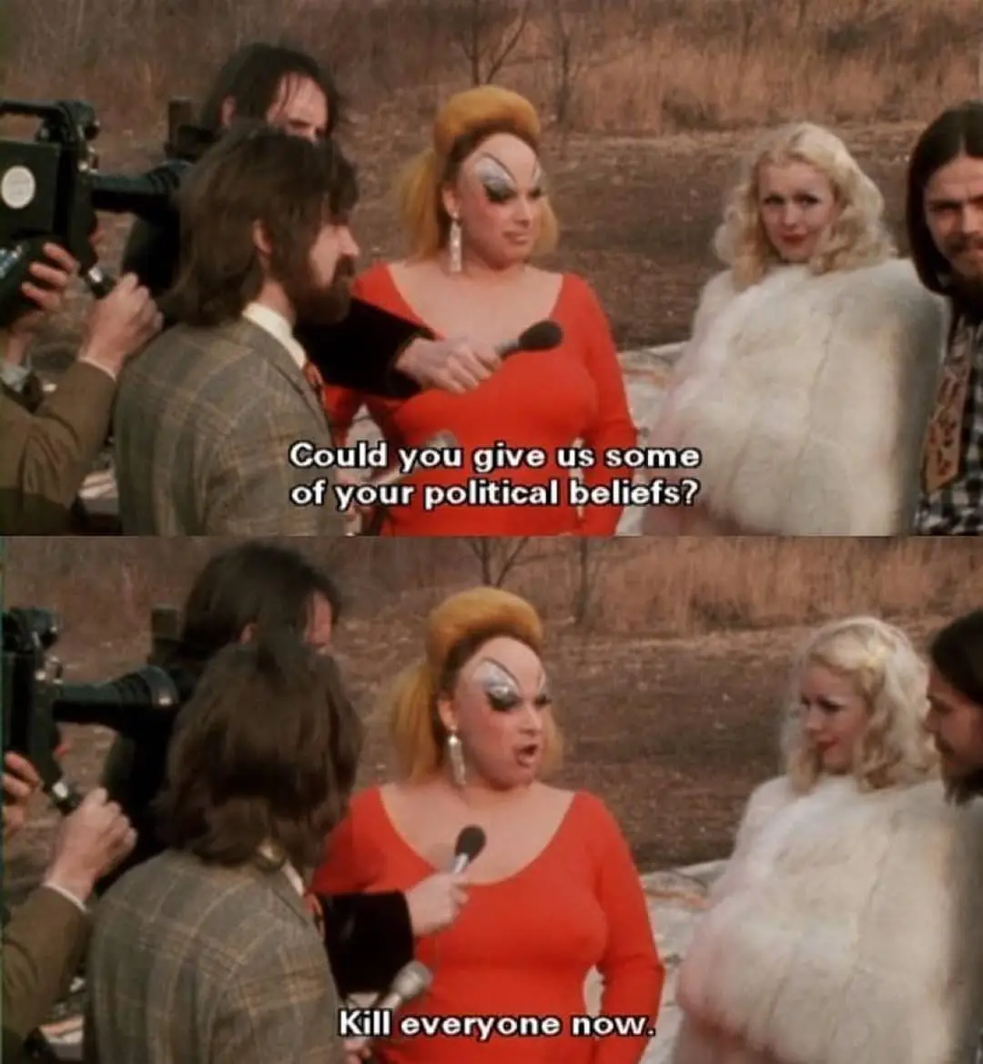 A two-panel meme from the 1970s film 'The Rocky Horror Picture Show' shows a drag queen in a red dress and dramatic makeup…