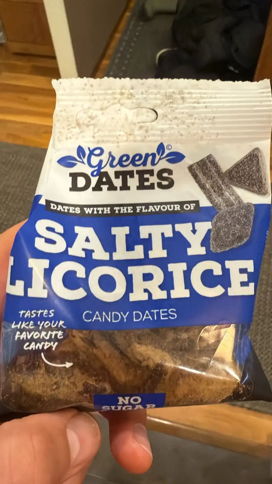 A hand holds a bag of 'Green Dates' candy, which is labeled as 'Dates with the flavour of Salty Licorice' and 'Candy Dates'…