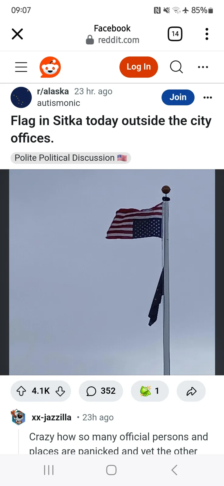 A screenshot of a Reddit post from r/alaska showing a photo of an American flag flying on a pole against an overcast sky…