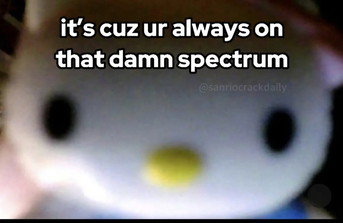 A blurry close-up of a white, round-faced plush toy with black eyes and a yellow beak-like nose, overlaid with the text…