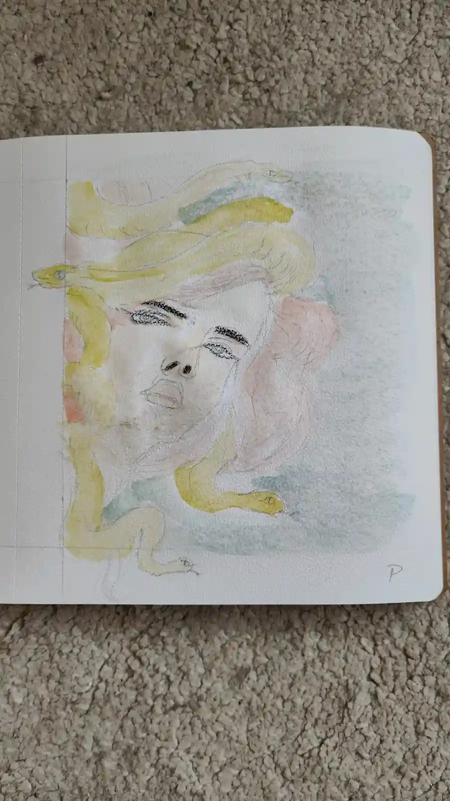 A watercolor sketch in a notebook depicts a woman's face with multiple yellow snakes coiling around her head and shoulders…