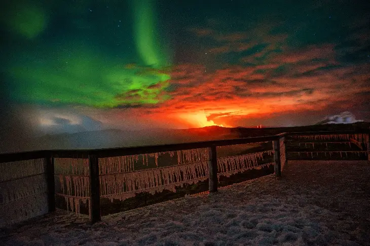 A stunning nighttime landscape photo shows vibrant green aurora borealis dancing across a starry sky, juxtaposed with a…