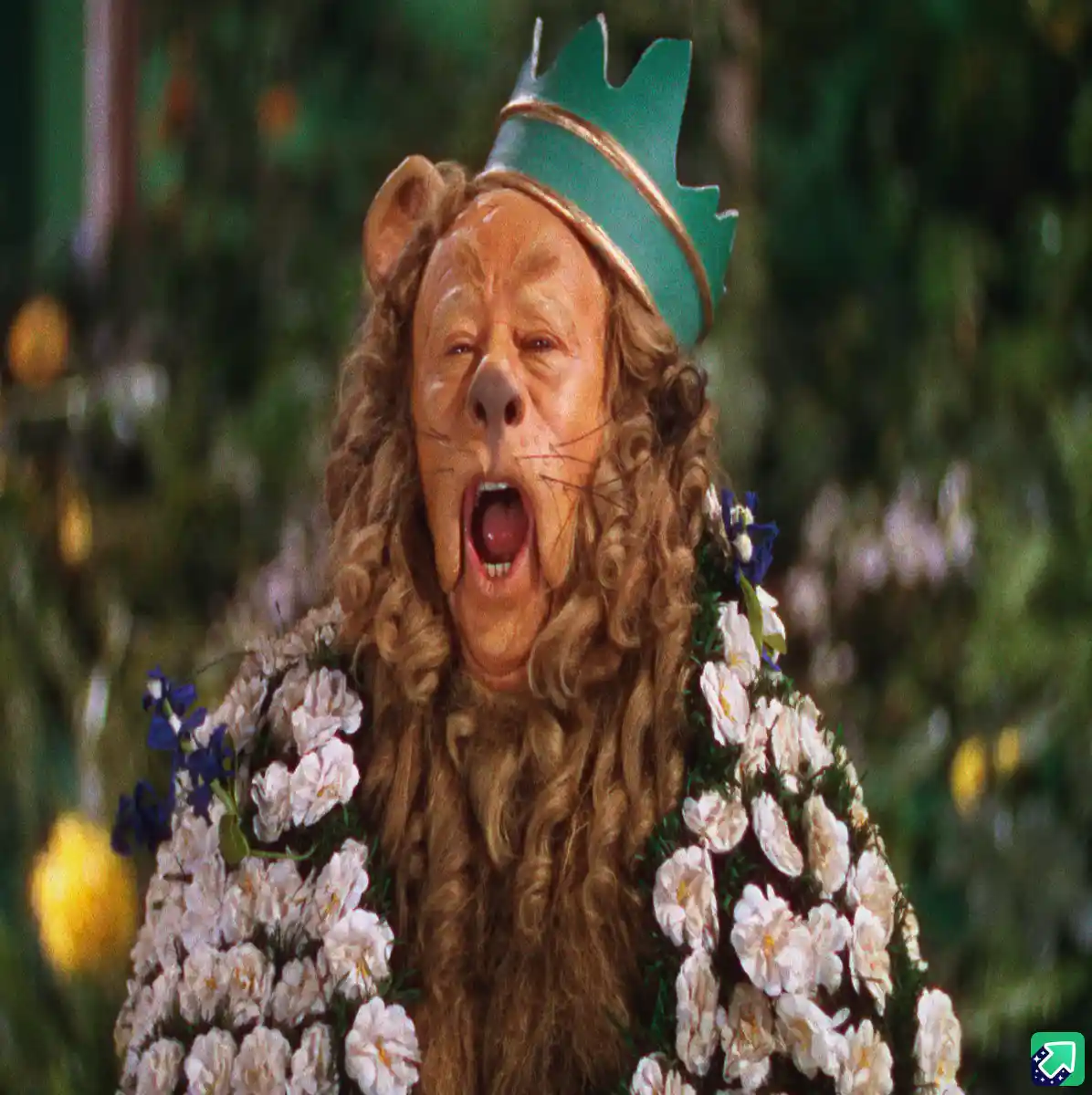A still image of the Cowardly Lion from The Wizard of Oz, wearing a green crown and a floral robe, with his mouth wide open…