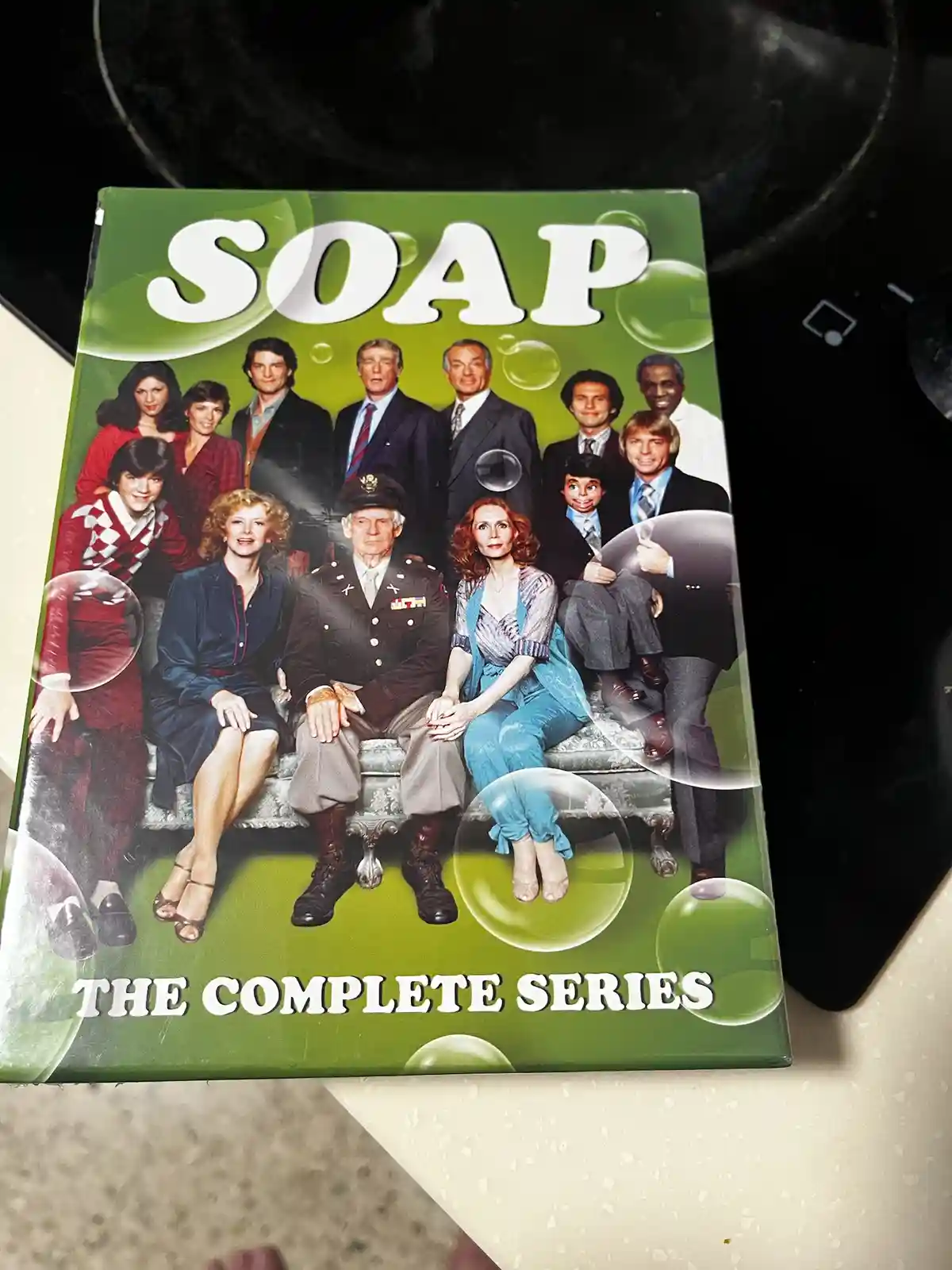 A DVD box set cover for the TV show 'Soap' featuring the cast in 1970s attire posing on a set, overlaid with the text 'soap…