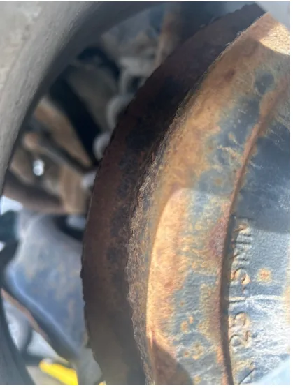 A close-up photo of a heavily rusted, circular metal part, likely a vehicle component, with the embossed text 'MINE 1500'…