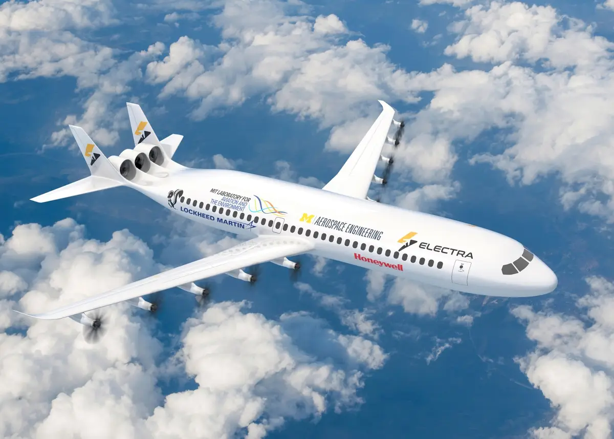 A white electric airplane with multiple propellers flies above fluffy white clouds against a blue sky. The fuselage is…