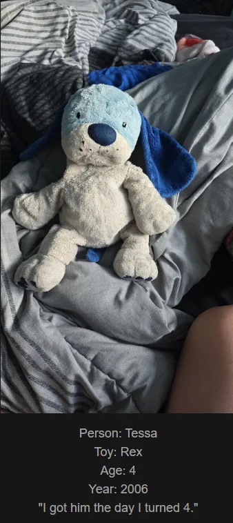 A light blue and white plush dog toy named Rex sits on rumpled gray bedding. Text overlaid at the bottom identifies the…