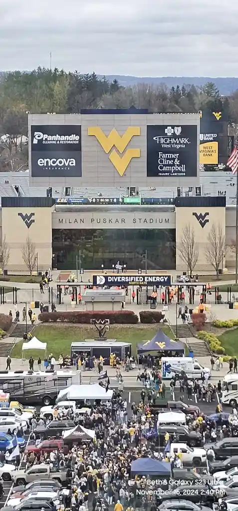 An aerial view of Milan Puskar Stadium, home of West Virginia University, shows a large crowd of fans in yellow and blue…