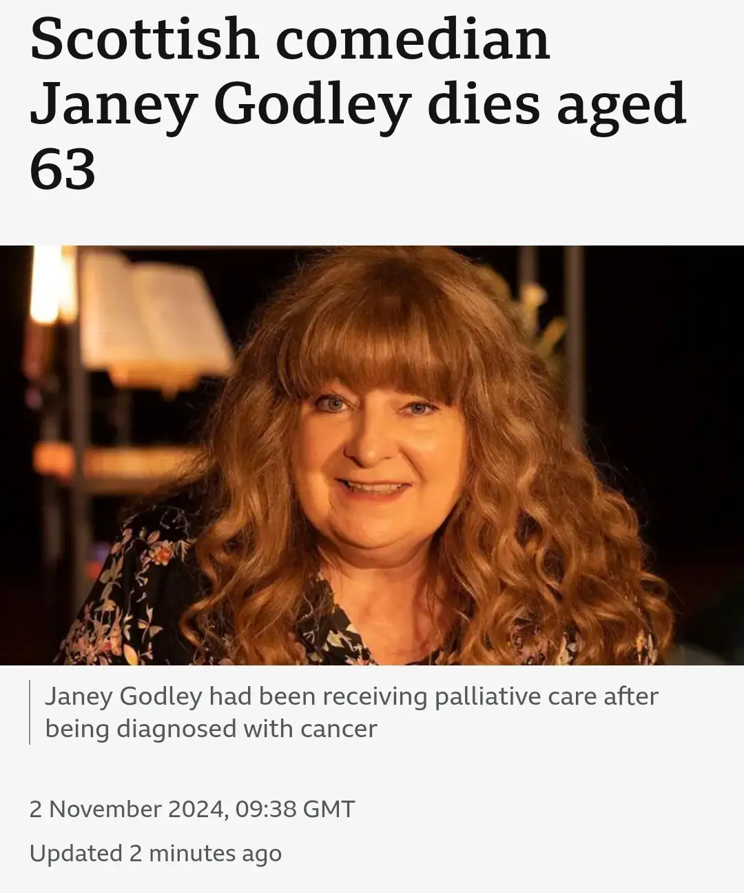 The image displays a news article screenshot with a photo of a smiling woman with long, wavy reddish-brown hair and bangs…