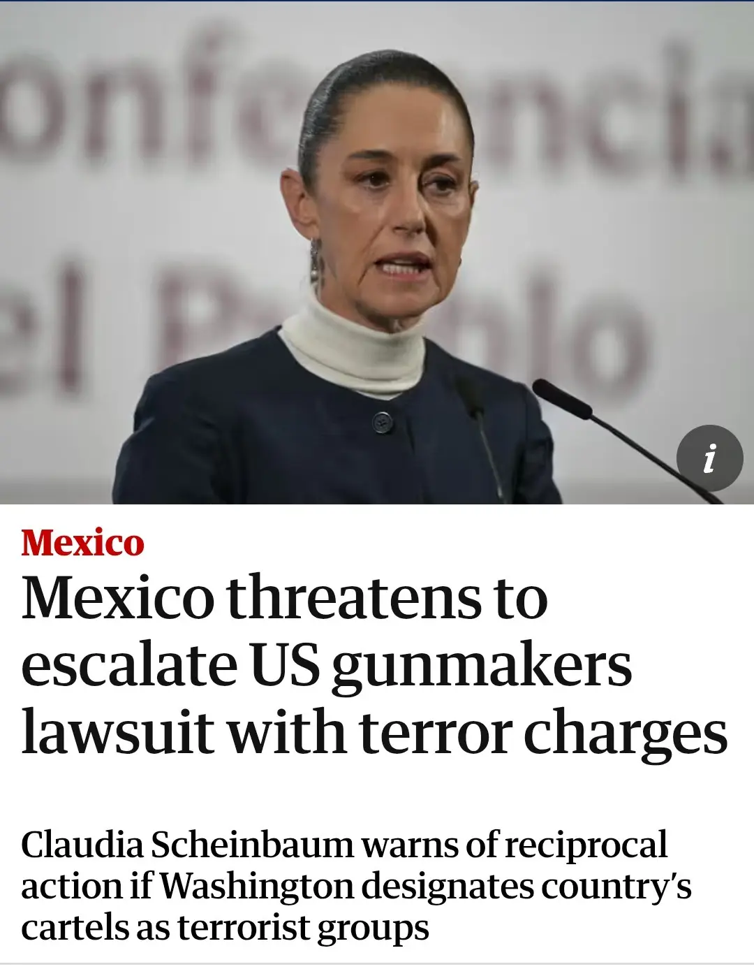 A woman in a dark blazer and white turtleneck speaks at a podium with microphones, set against a blurred background with…