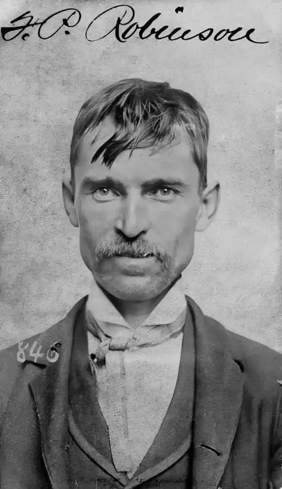 A vintage black-and-white mugshot-style portrait of a man with a mustache and formal attire, labeled 'J.P. Robinson' at the…