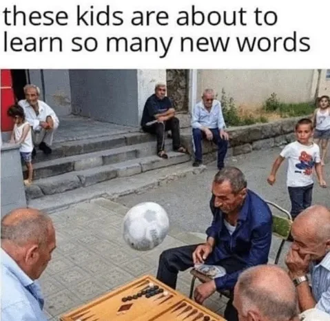 An outdoor scene shows several elderly men sitting on steps and chairs, playing backgammon and watching a soccer ball bounce…