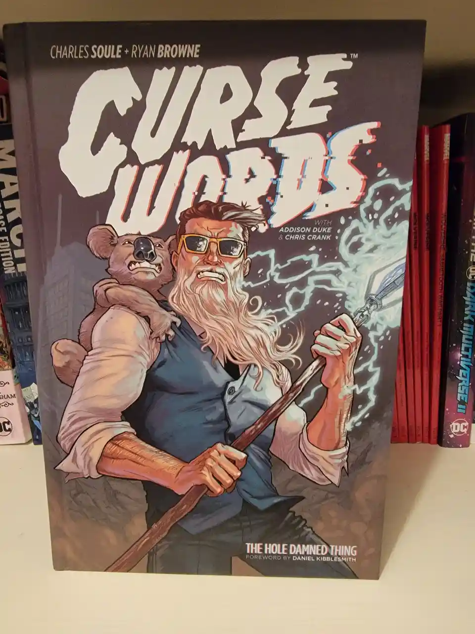 A comic book titled 'Curse Words' by Charles Soule and Ryan Browne, featuring a bearded man with sunglasses holding a staff…