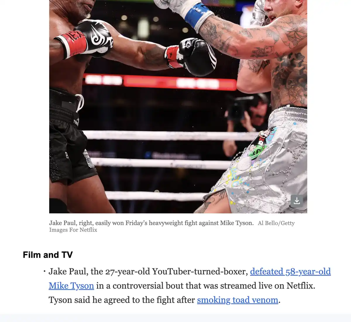 Two boxers are in a ring, one with black shorts and red/black gloves, the other with silver shorts and heavily tattooed…