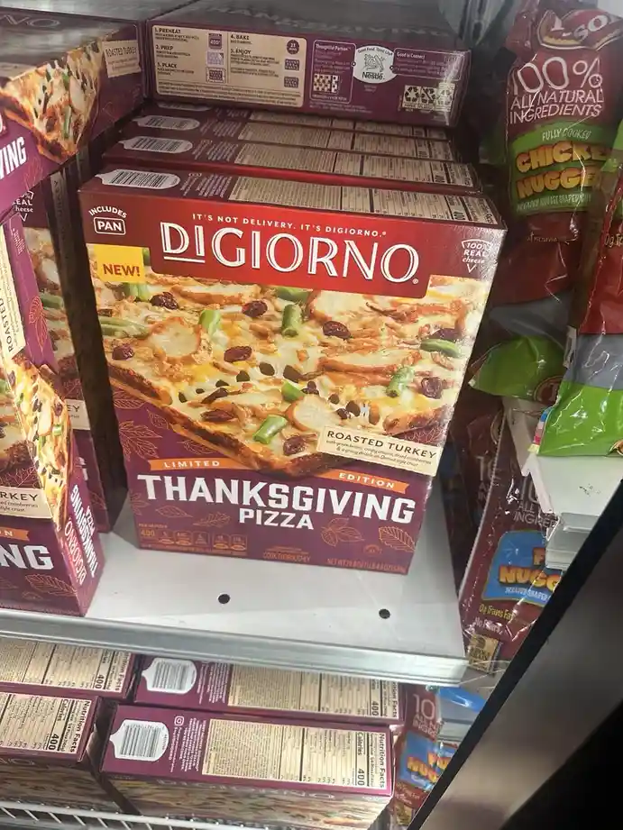 A grocery store shelf displays boxes of DiGiorno's 'Limited Edition Thanksgiving Pizza' with roasted turkey, green beans…