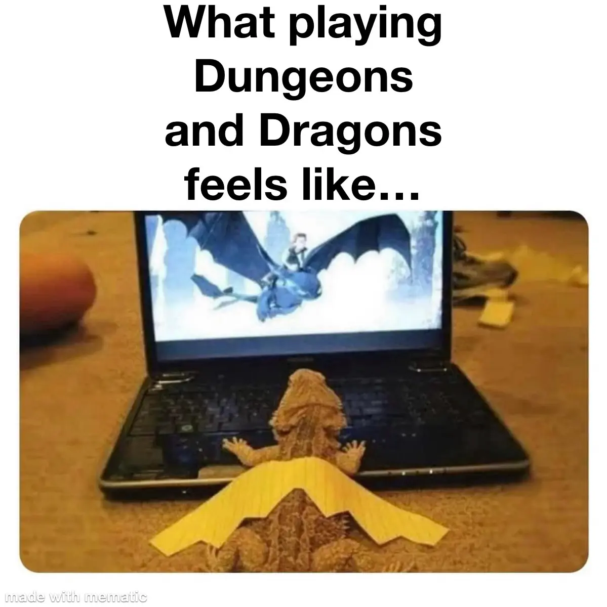 A bearded dragon sits on a carpet in front of an open laptop, with yellow paper wings taped to its back. The laptop screen…