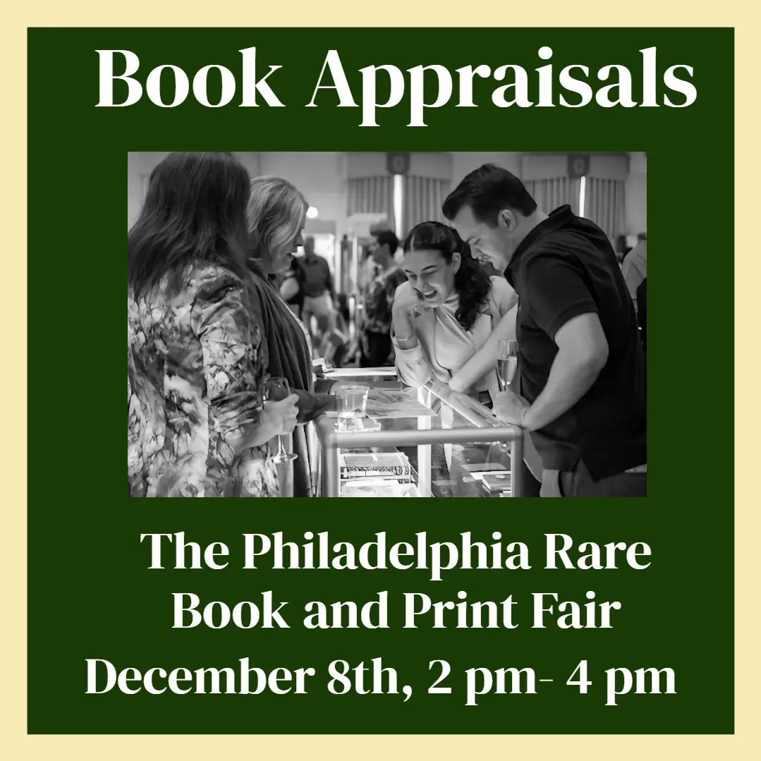A black-and-white photo shows four people gathered around a glass-topped table at what appears to be a book fair. Two women…