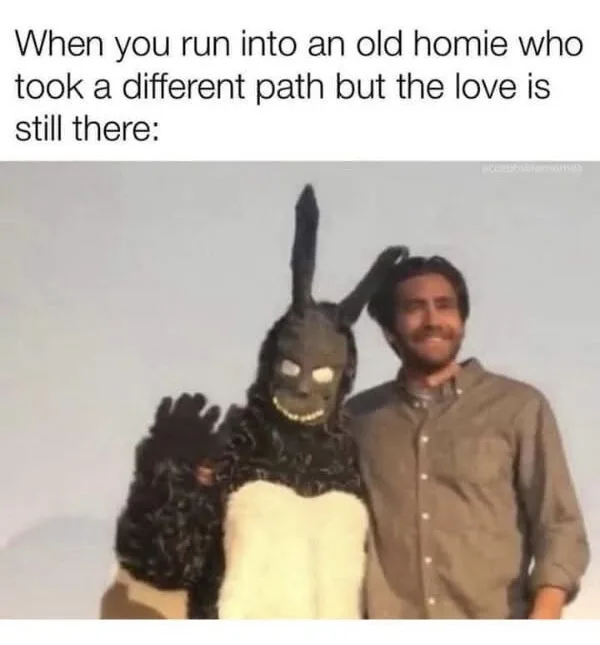 A man in a brown button-up shirt stands next to a person in a black and white bunny costume with glowing eyes and a wide…
