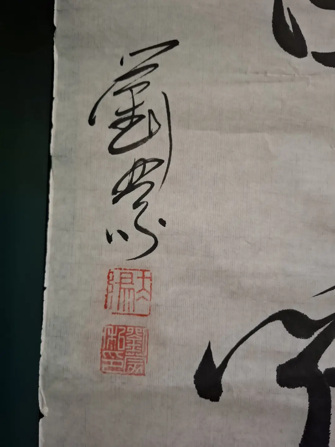 A close-up of traditional Chinese calligraphy on textured paper, featuring a vertical black ink signature reading '劉墉' and…