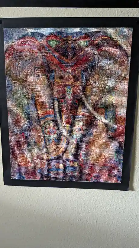 A colorful bead mosaic artwork depicting a stylized, abstract scene with multiple figures and vibrant patterns, framed in…