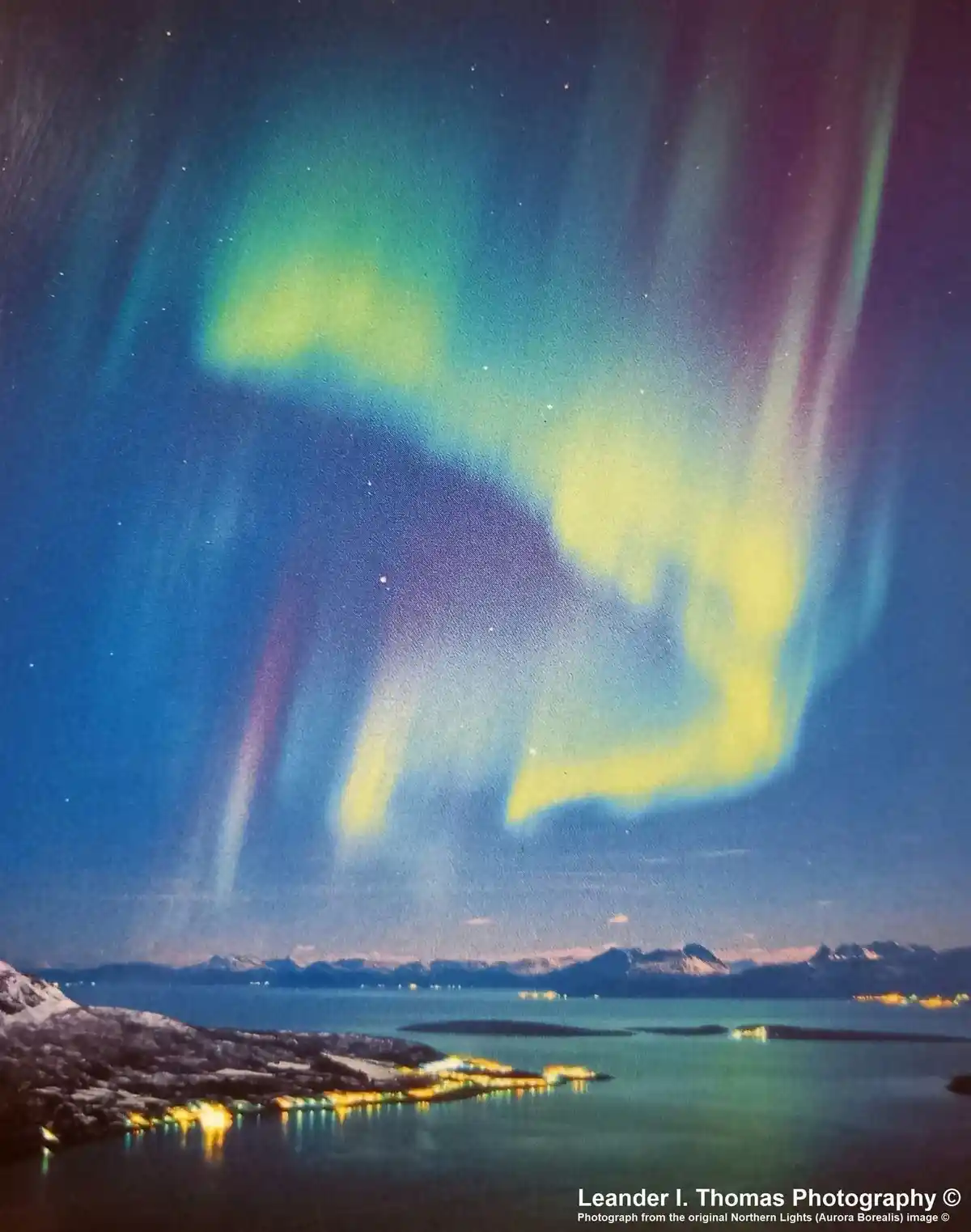 A stunning photograph of the aurora borealis, with vibrant green and purple lights dancing across a starry night sky above a…