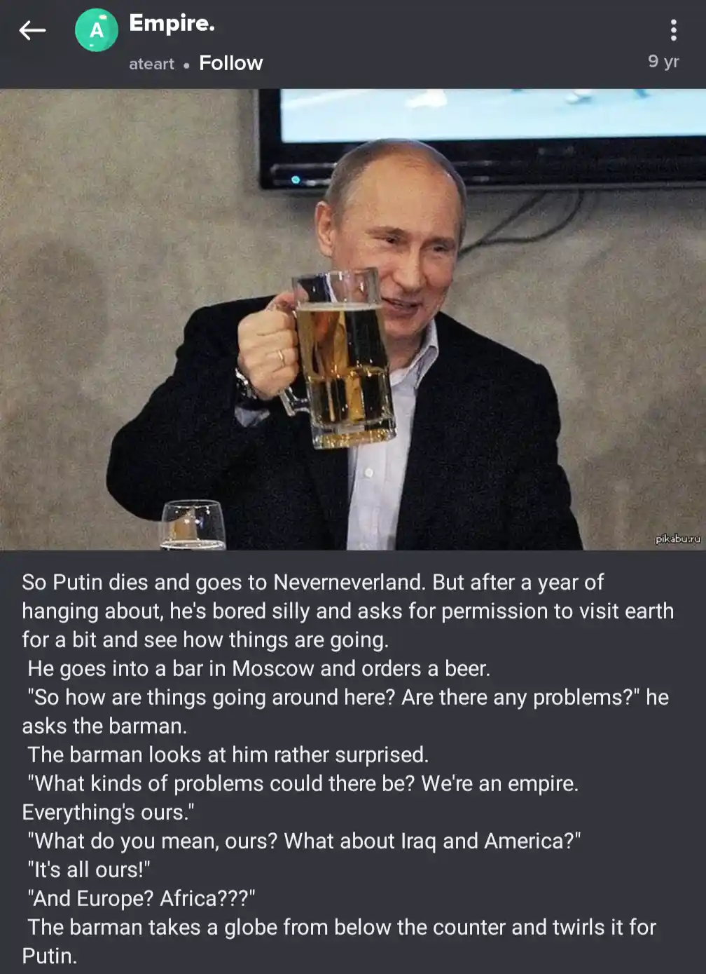 A man in a dark suit holding a large beer mug smiles while seated at a table with a small glass of water. A dark text box…