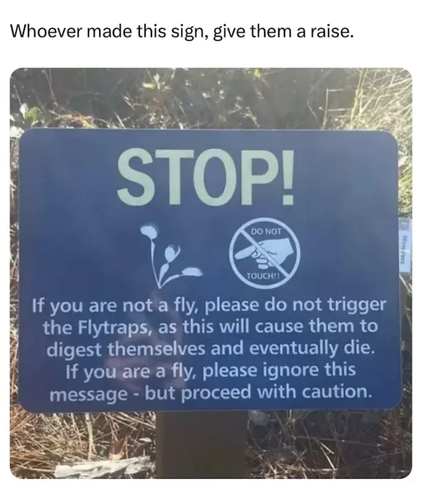 A blue warning sign with 'STOP!' in large letters, a drawing of a Venus flytrap, and a 'DO NOT TOUCH!' symbol. The text…