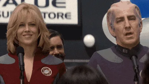A still from the movie 'The Fifth Element' shows a woman and a man in futuristic uniforms standing at microphones in front…