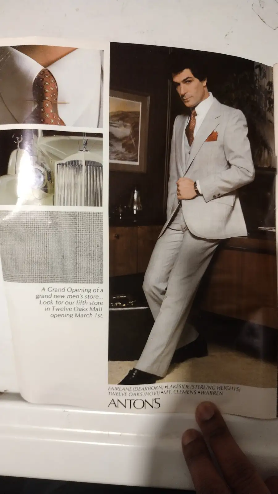 A vintage Anton's men's clothing store advertisement featuring a man in a light gray suit with an orange patterned tie and…