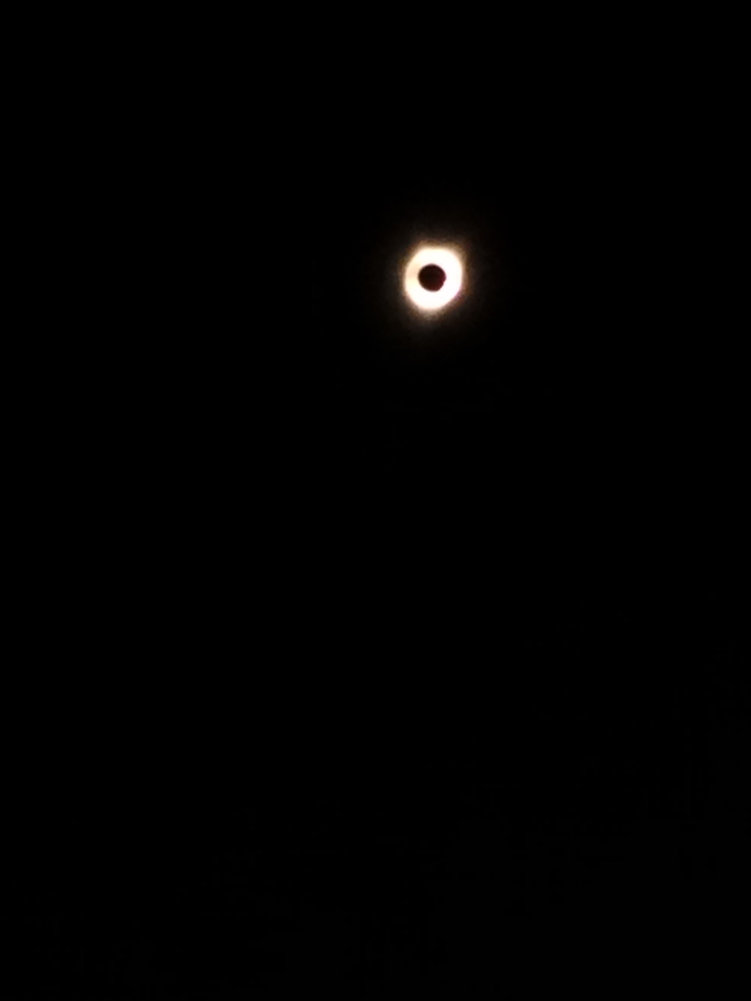 A dark sky with a bright, glowing ring of light centered in the frame, resembling a solar eclipse. The overlaid text reads…