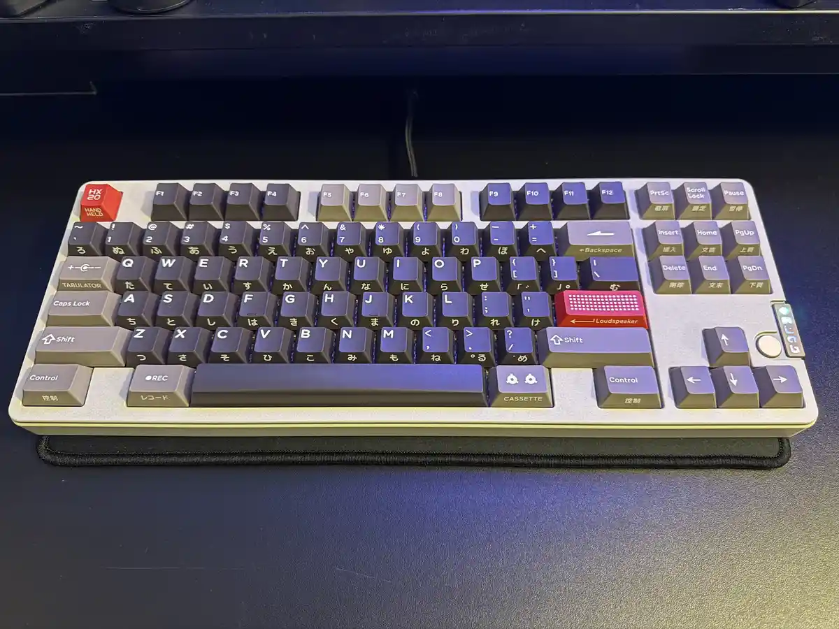 A close-up photo of a custom mechanical keyboard with a retro design, featuring keys labeled with Japanese characters and…